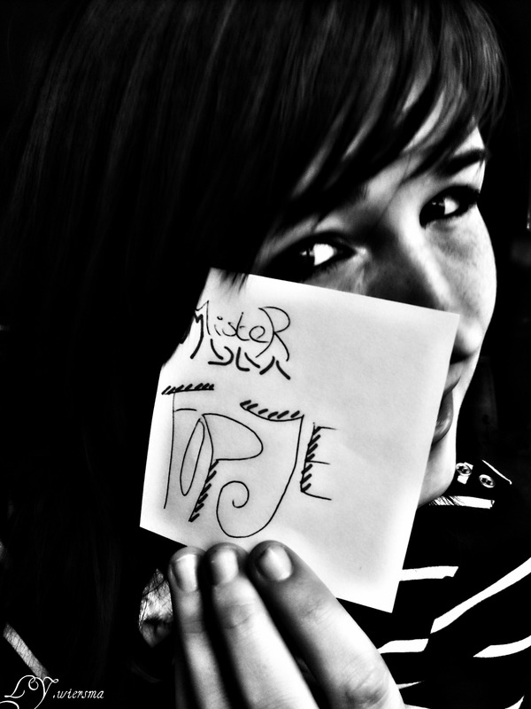 Girl holds handwritten note up to camera
