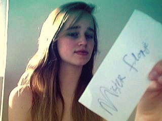 Member holds up handwritten sign for forum proof