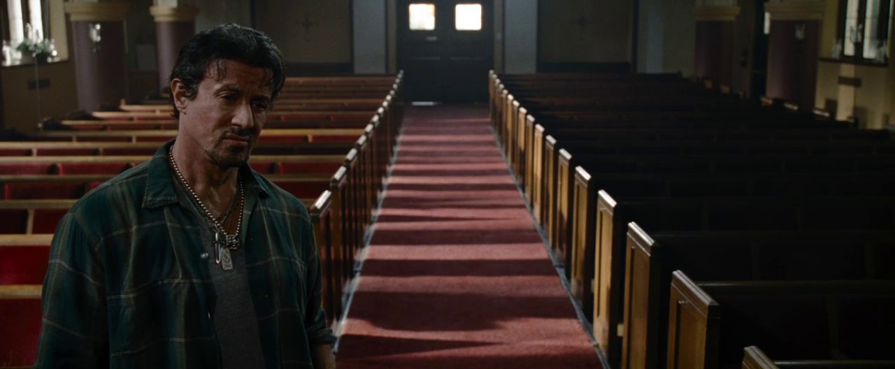Lone figure walking down empty church aisle