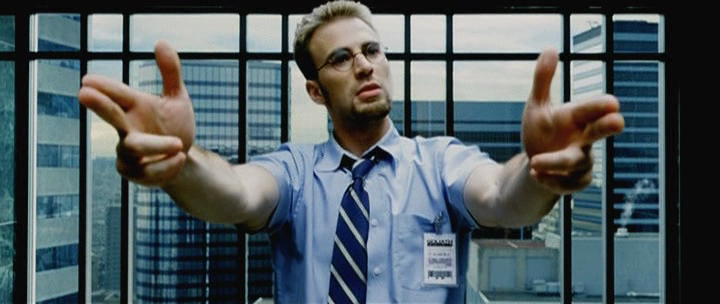Movie still: guy reaching toward camera in office