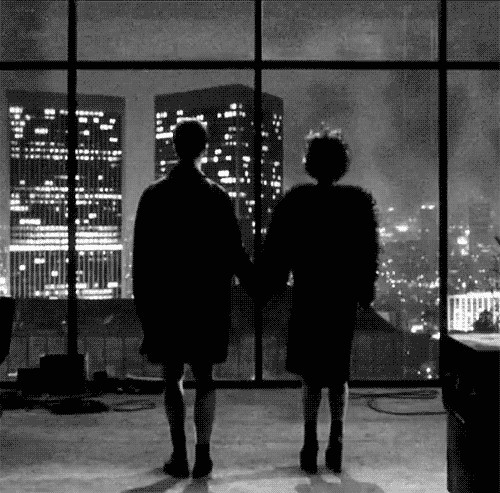 Silhouetted couple gazing at glittering city skyline