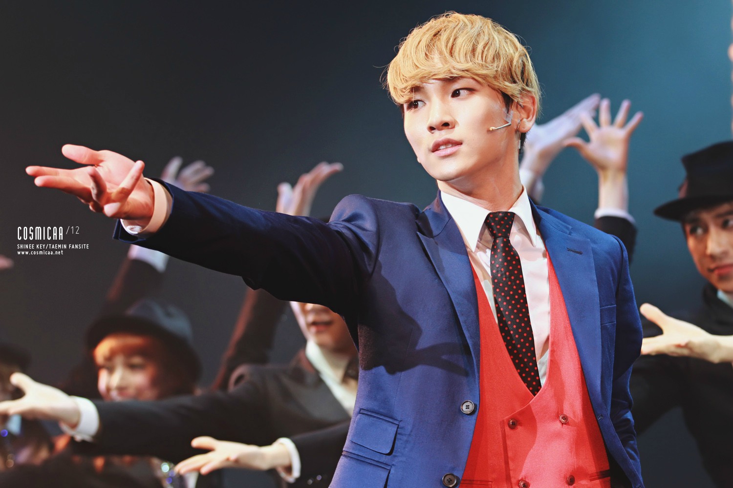 K-pop idol mid-performance, blue suit and red vest